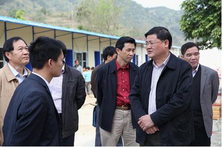 图为黄志伟(右二)在平果县同老乡中心小学调研.